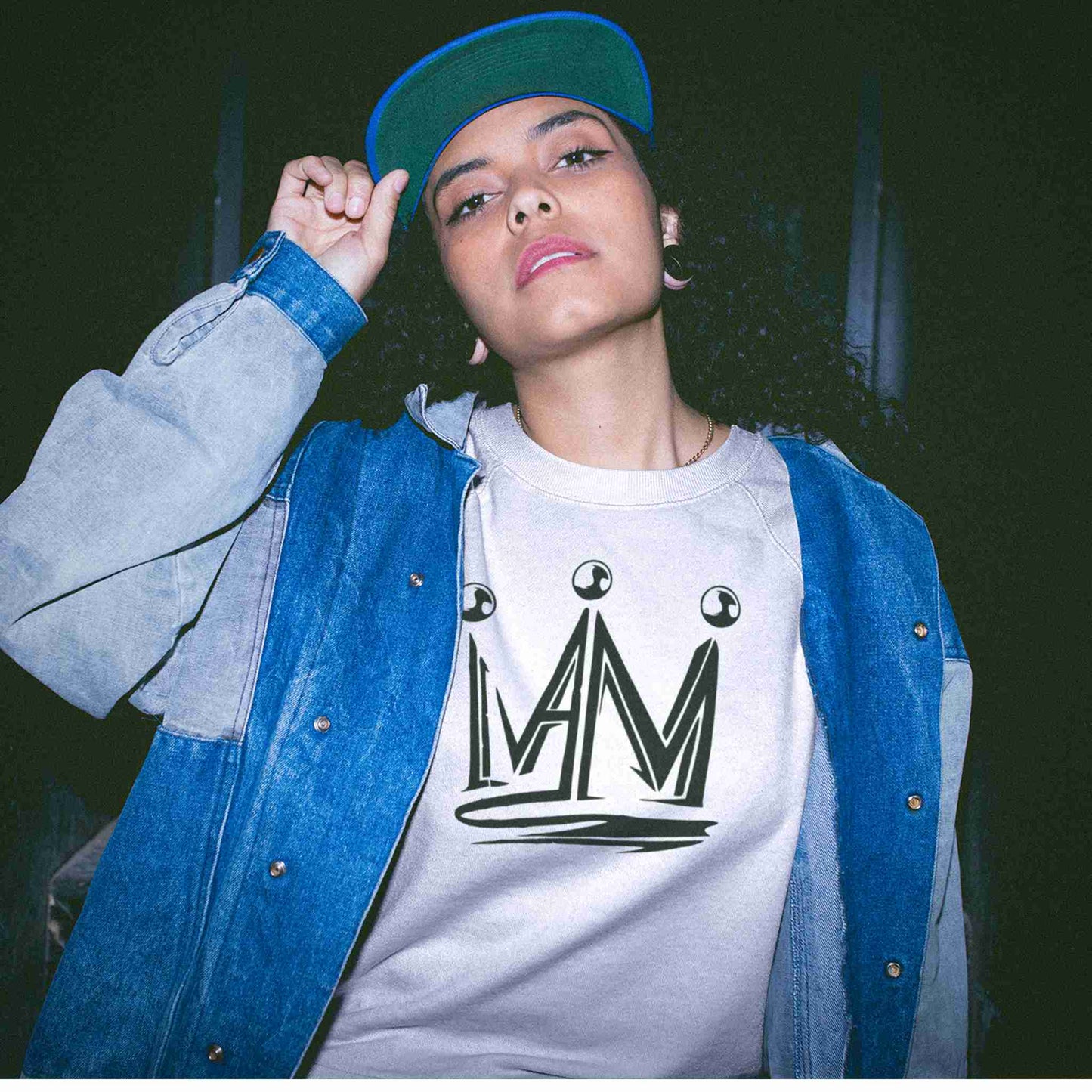 Young lady wearing an I Am crown sweatshirt under a denim jacket