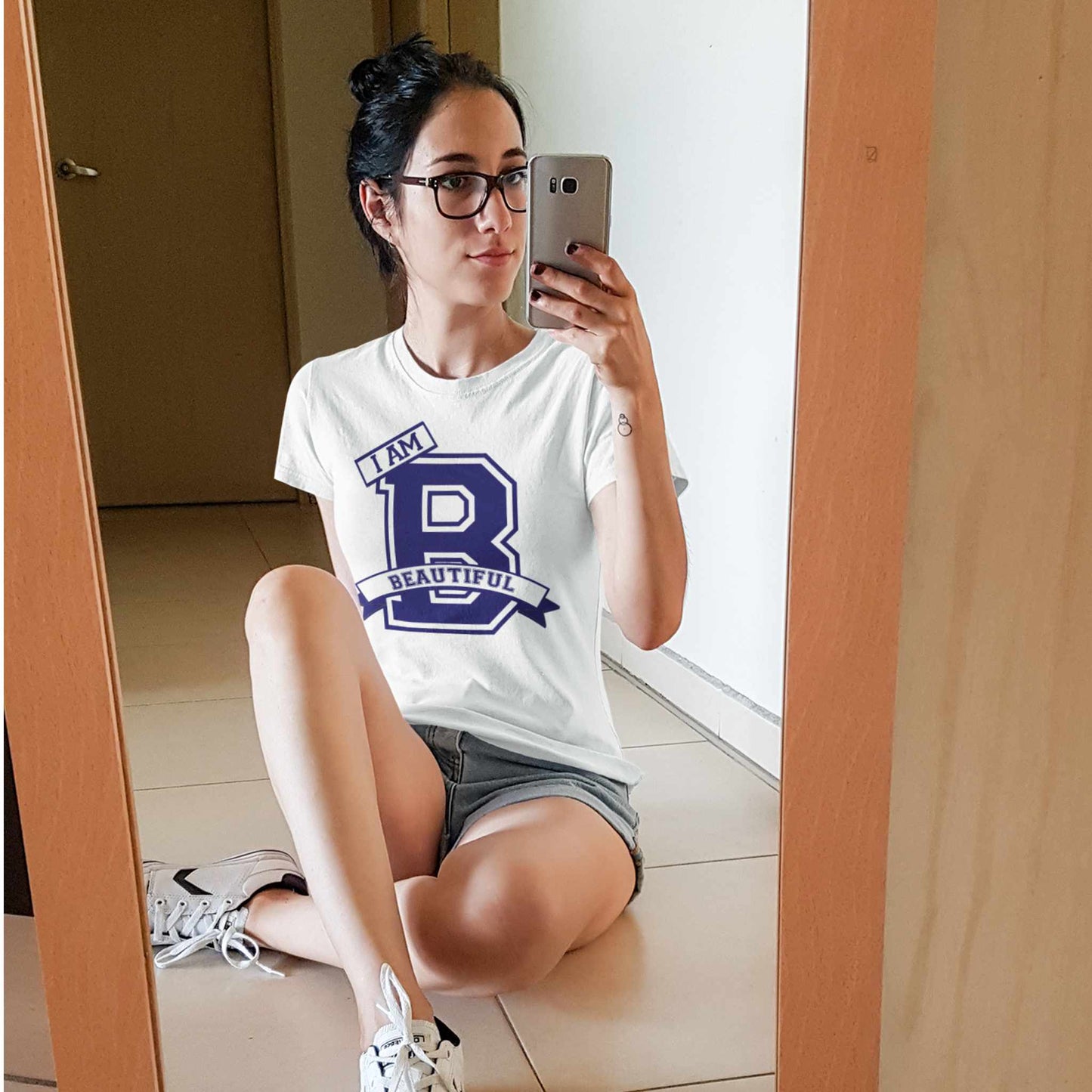 Woman sitting in front of the mirror wearing a I Am Beautiful tee